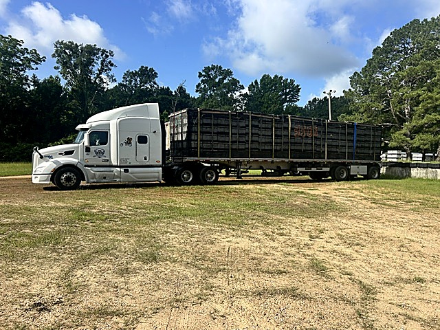 A flatbed trailer loaded with bee hives, ready for the road