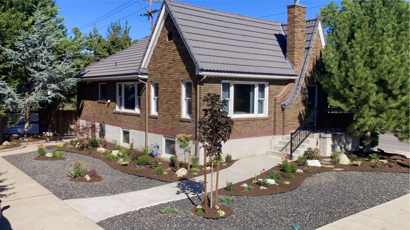 Finished water-wise front yard with gravel, river rock, and mature planting beds