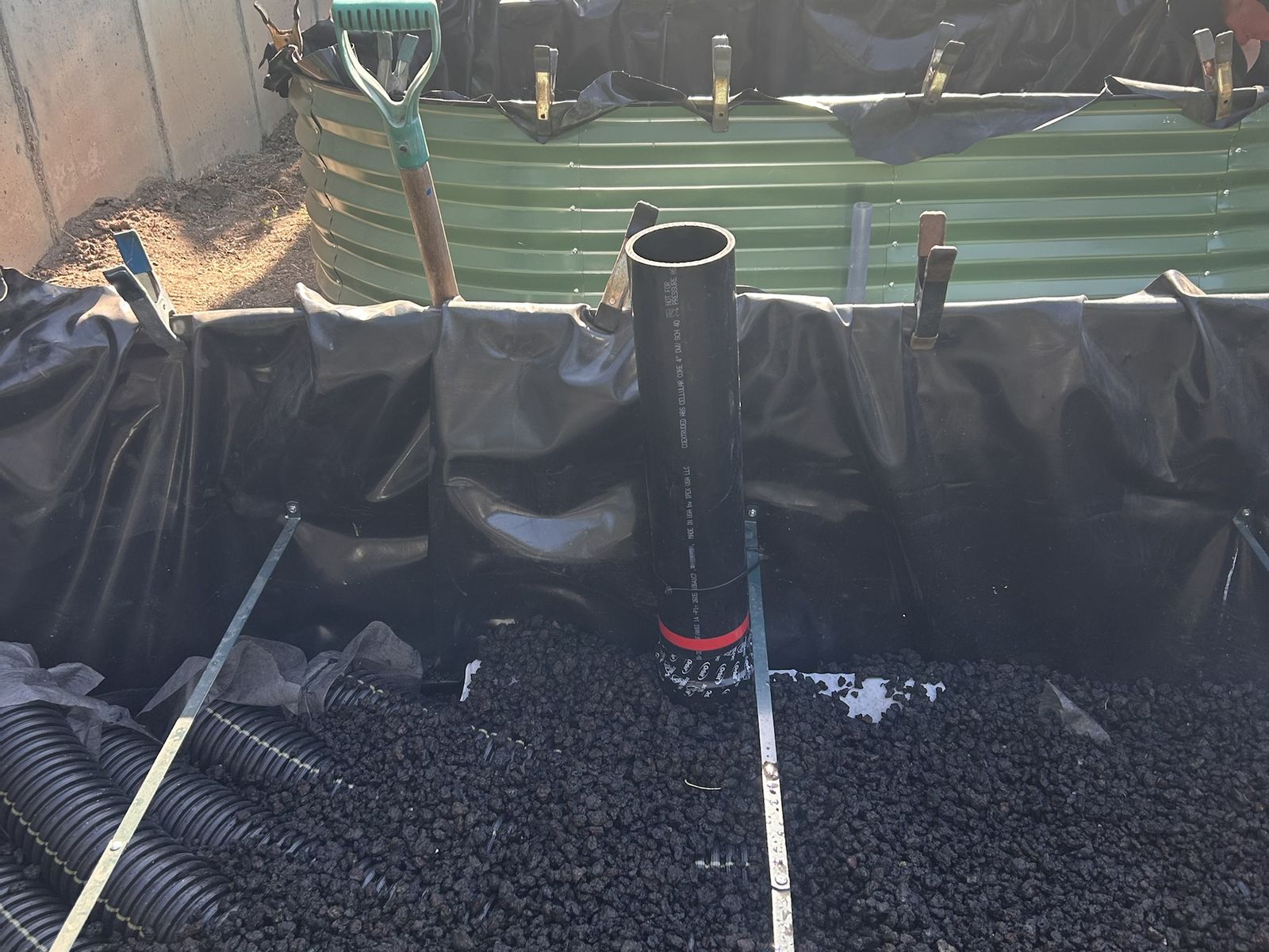 Corrugated perforated pipe and lava rock filling the reservoir around the standpipe