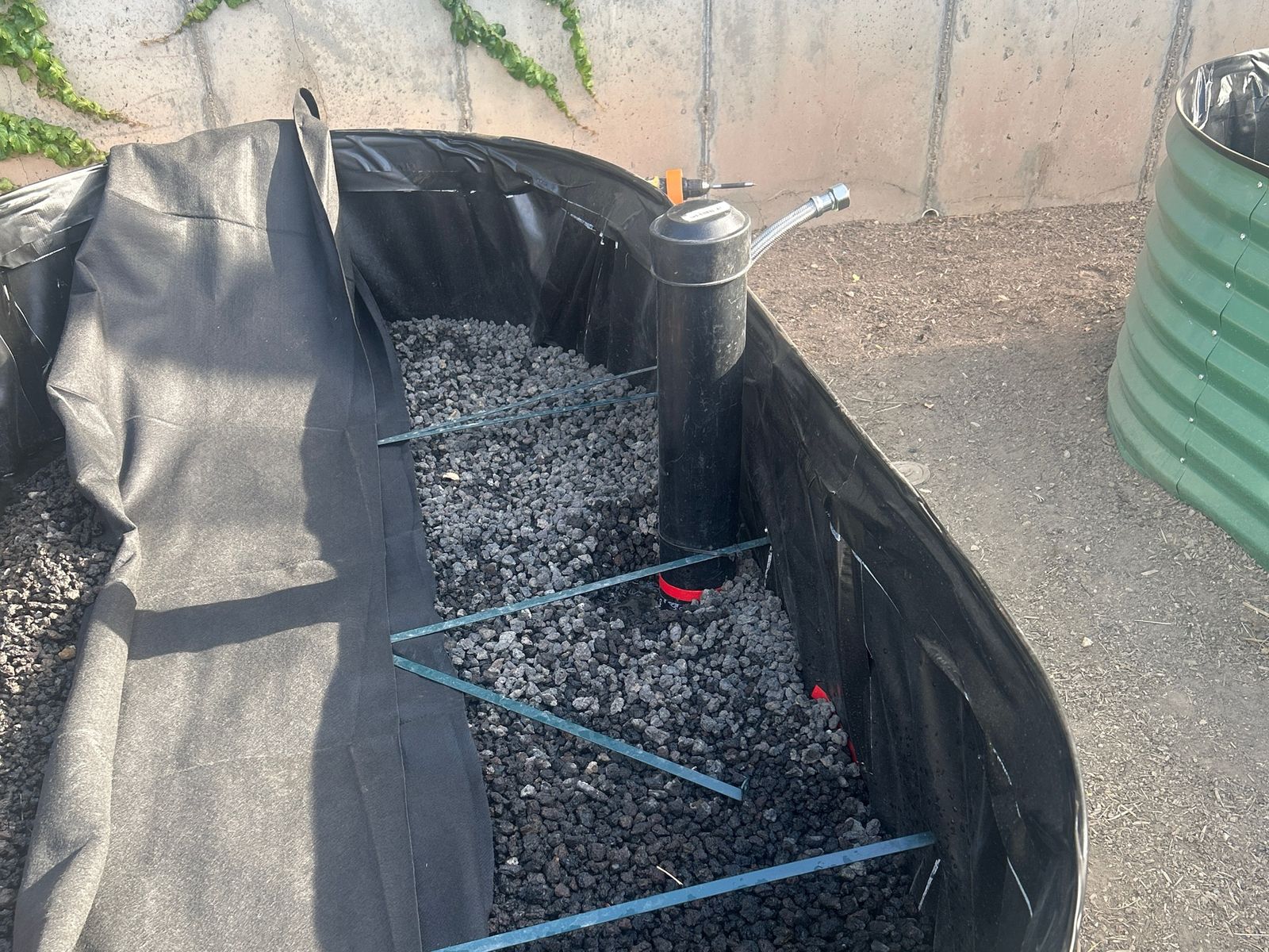 Standpipe fitted with a fill valve and hose connection above the rock layer